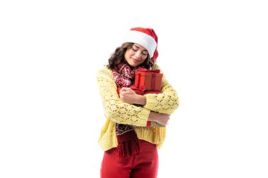 Noel Baba şapkası ve eşarplı neşeli genç bir kadın. Beyaz eşarpta izole edilmiş hediyeler.