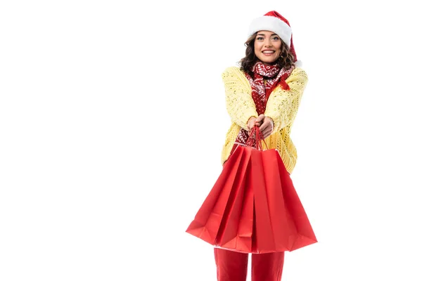 头戴圣诞礼帽 头戴围巾 头戴装饰品 头戴红色购物袋 与白色隔离的快乐的年轻女子 — 图库照片