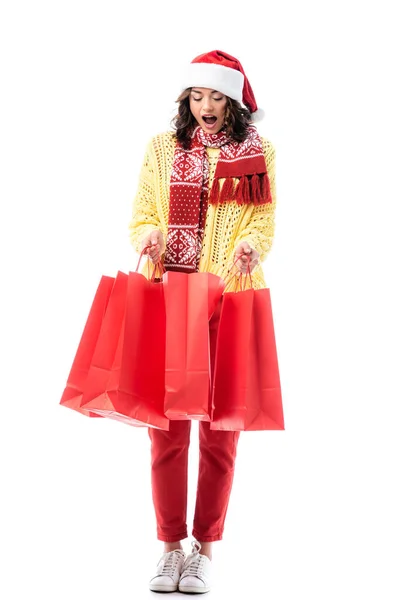 Wstrząśnięta Młoda Kobieta Kapeluszu Szaliku Santa Ozdobą Trzymając Czerwone Torby — Zdjęcie stockowe