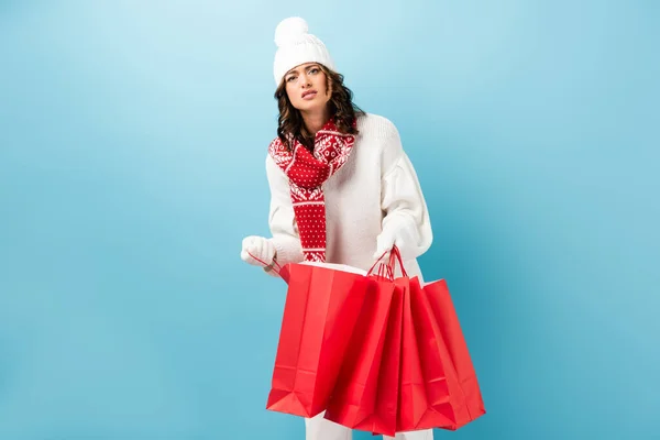 Displeased Woman Winter Outfit Holding Red Shopping Bags Blue — Stock Photo, Image