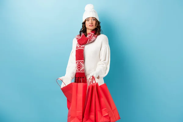 Surprised Woman Winter Outfit Holding Red Shopping Bags Blue — Stock Photo, Image