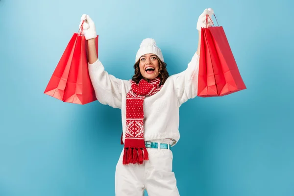 Podekscytowana Młoda Kobieta Stroju Zimowym Trzymając Czerwone Torby Zakupy Patrząc — Zdjęcie stockowe