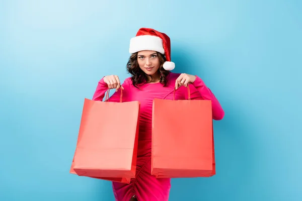 Young Brunette Woman Santa Hat Holding Shopping Bags Looking Camera — Stock Photo, Image
