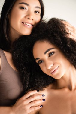 Mutlu Afro-Amerikan ve Asyalı kadınlar beyazlara sarılıyorlar.