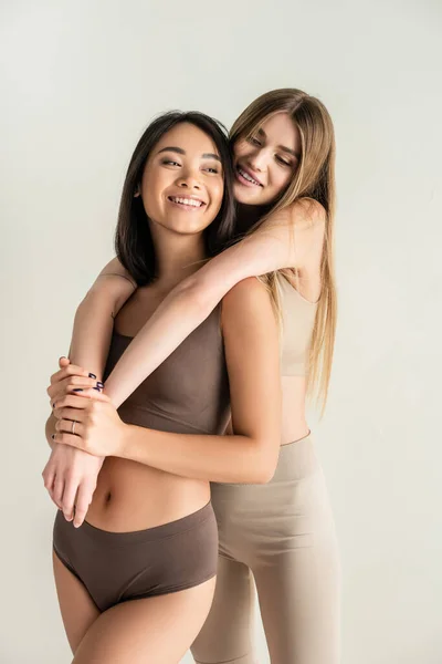 Blonde Woman Hugging Happy Asian Model While Posing Isolated White — Stock Photo, Image