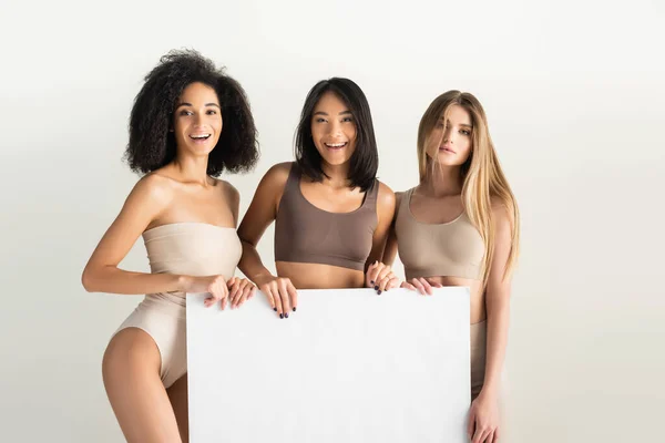 Mulheres Inter Raciais Alegres Roupa Interior Bege Segurando Cartaz Branco — Fotografia de Stock