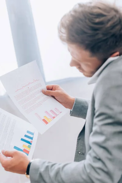 Geschäftsmann Hält Dokumente Mit Diagrammen Der Hand Während Auf Dem — Stockfoto