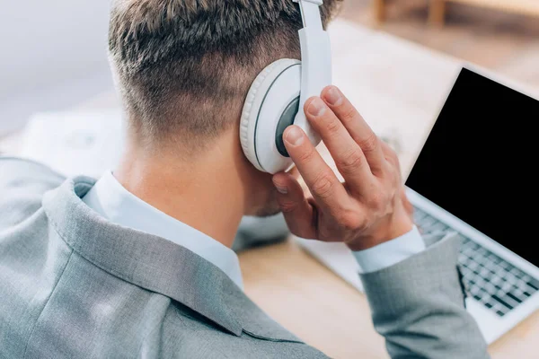 Back View Businessman Touching Headphones While Using Laptop Blurred Background — Stock Photo, Image