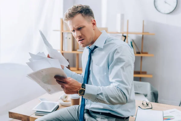 Embarrassed Businessman Looking Documents Working Table Blurred Background — Stock Photo, Image