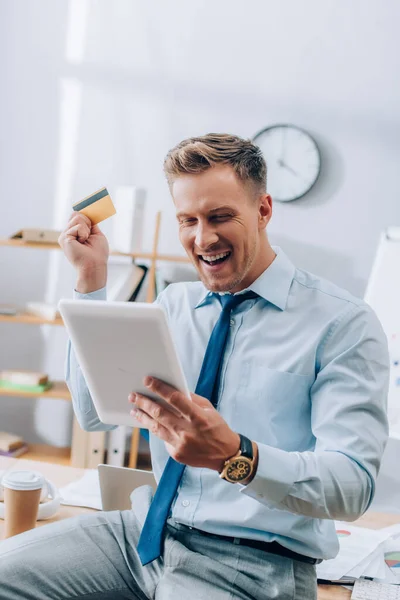 Hombre Negocios Alegre Mirando Tableta Digital Mientras Sostiene Tarjeta Crédito — Foto de Stock