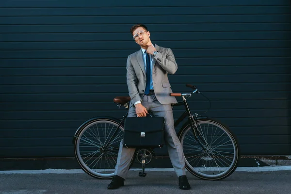 Evrak Çantalı Genç Işadamı Motosikletin Yanında Kameraya Bakıyor — Stok fotoğraf