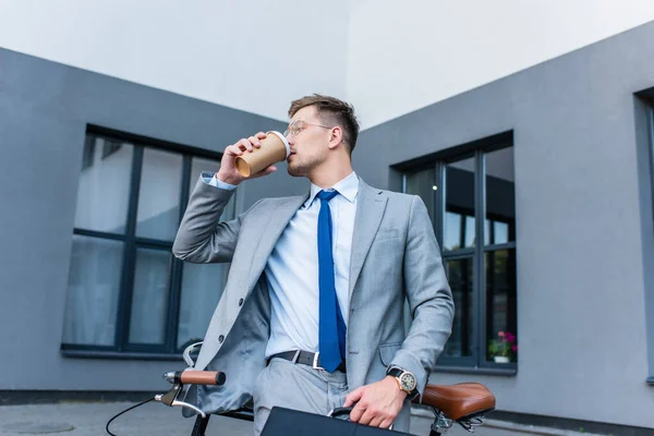 Empresario Bebiendo Café Para Llevar Mientras Sostiene Maletín Cerca Bicicleta — Foto de Stock