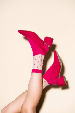 Pembe retro çoraplı kadın bacakları ve bej arka planda ayakkabılar.