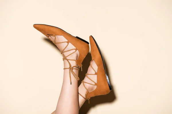 Kahverengi Süet Ayakkabılı Bej Arka Planda Kadın Bacakları — Stok fotoğraf