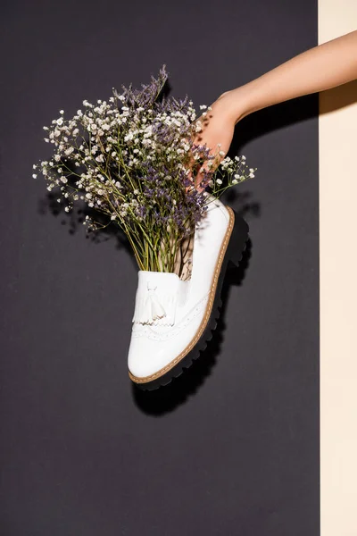 Cropped View Woman Holding White Shoe Wildflowers Black Background — Stock Photo, Image