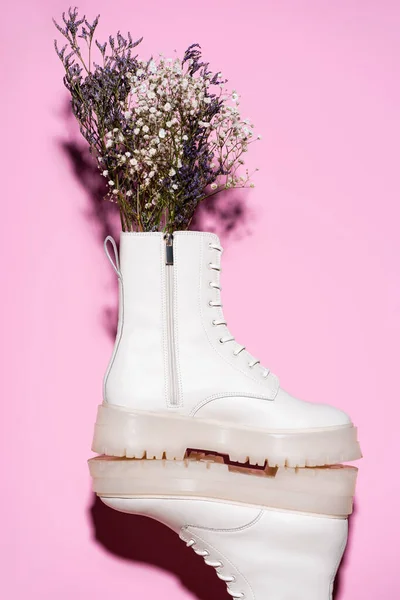 White boots with wildflowers on pink background — Stock Image White Boots Wildflowers Pink Background Stock Image