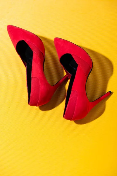 Sarı Zemin Üzerinde Kırmızı Süet Topuklu Ayakkabıların Üst Görünümü — Stok fotoğraf