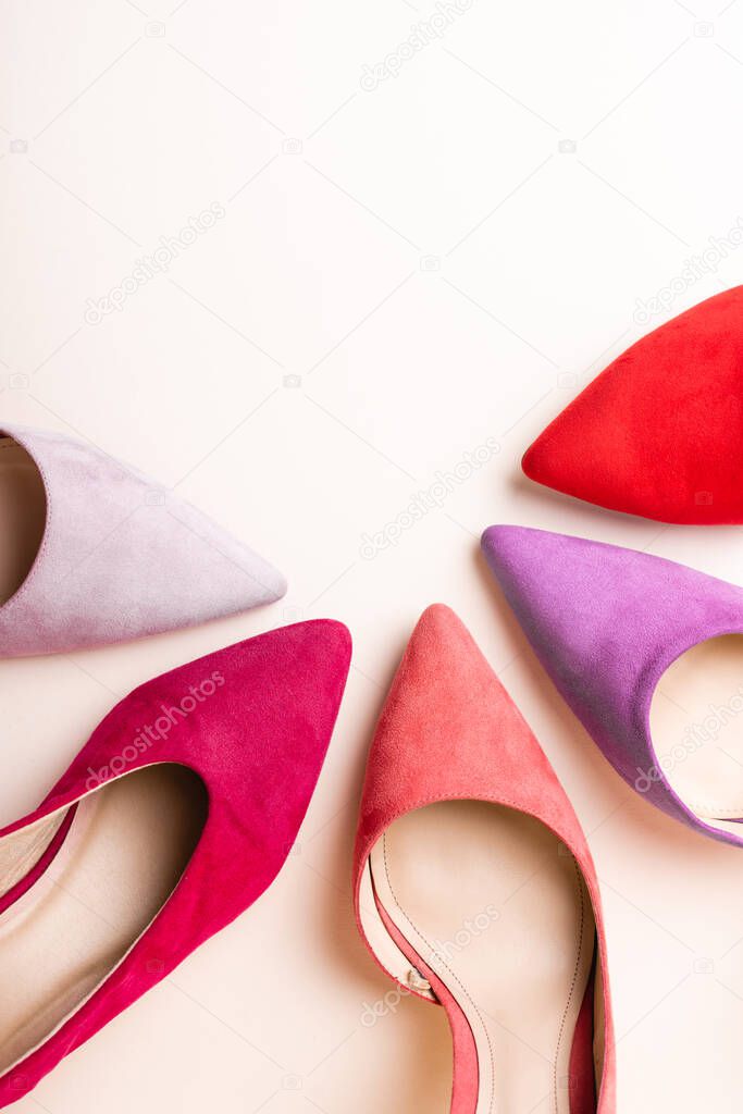 top view of suede colorful heeled shoes on beige background