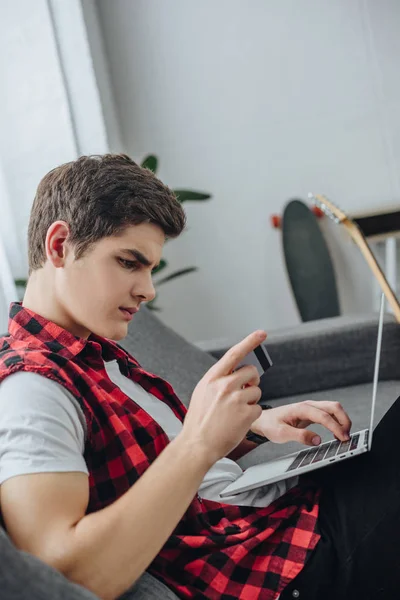 Adolescente usando laptop e cartão de crédito em casa — Fotografia de Stock