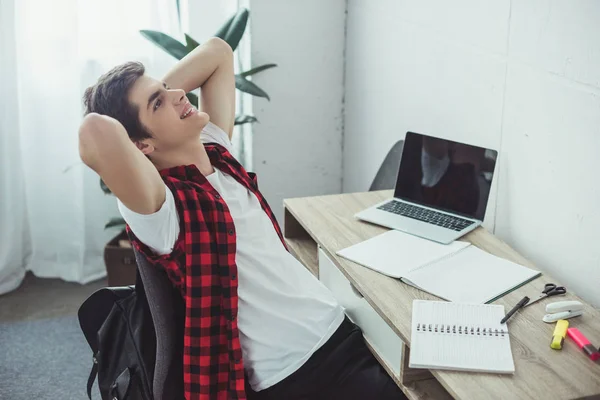 Dreamy student doing homework with laptop and copybooks at home — Stock Photo