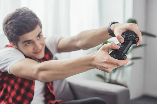 Selective focus of teenager playing video game with joystick at home — Stock Photo