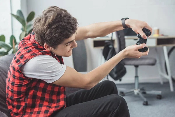 Animado teen gamer jogar vídeo game com joystick em casa — Fotografia de Stock