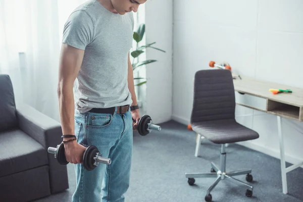 Jovem menino formação com halteres em casa — Fotografia de Stock