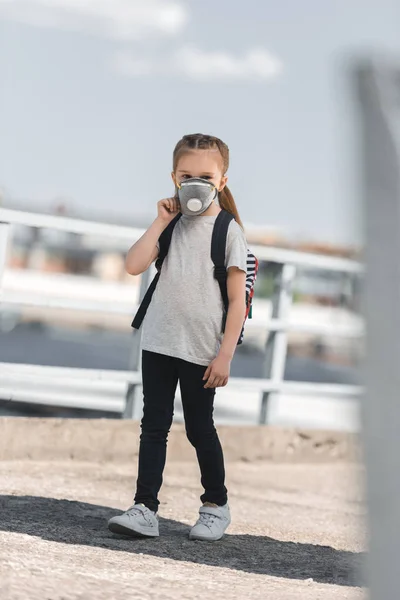 Kind in Schutzmaske läuft auf Brücke zur Schule, Luftverschmutzungskonzept — Stockfoto