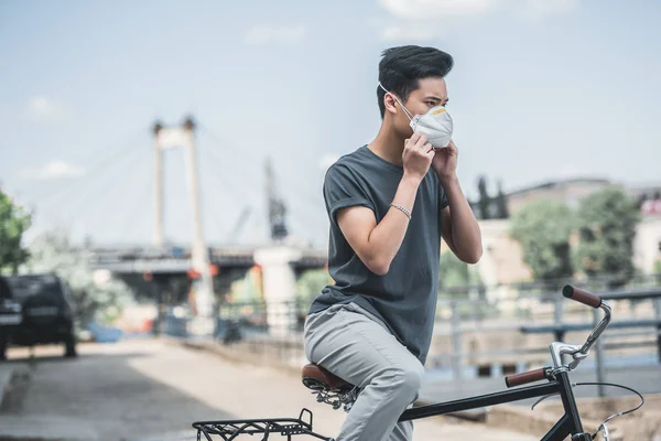 Asiatischer Teenager mit Schutzmaske mit Fahrrad, Luftverschmutzungskonzept — Stockfoto