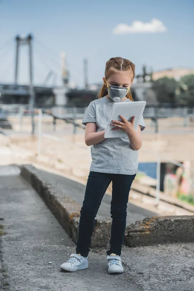 Kind in Schutzmaske mit Tablet auf der Straße, Luftverschmutzungskonzept — Stockfoto