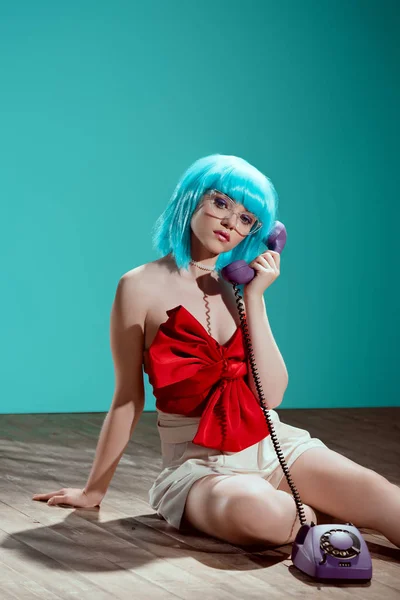 Beautiful fashionable female model talking by telephone and looking at camera — Stock Photo