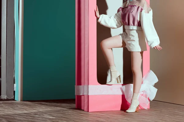 Обрізаний знімок модної молодої жінки позує в декоративній рожевій коробці з бантом — стокове фото