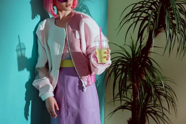 Cropped shot of girl in pink wig holding disposable cup with smoothie — Stock Photo