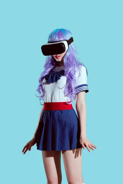 Chica con estilo en peluca brillante usando auriculares de realidad virtual aislados en azul - foto de stock