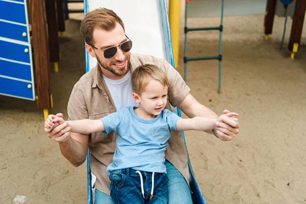 Vater und Sohn amüsieren sich auf Spielplatz im Park — Stockfoto
