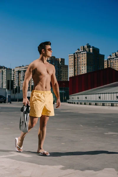 Sportlicher junger Mann ohne Hemd mit Schwimmflossen auf Parkplatz — Stockfoto