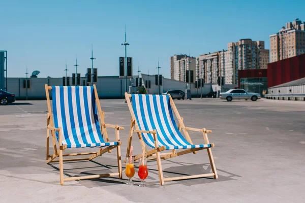 Lettini prendisole con cocktail nel parcheggio nella giornata di sole — Foto stock