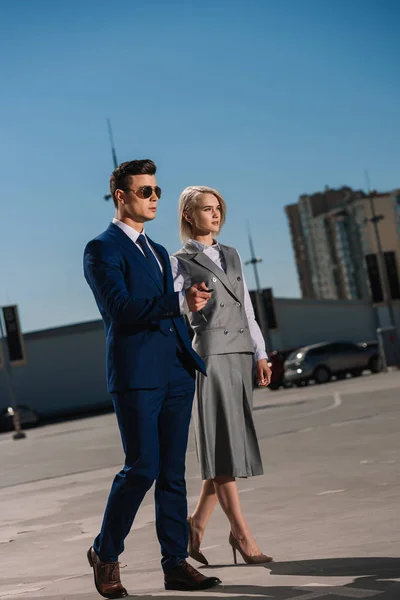 Young attractive business people walking on parking — Stock Photo
