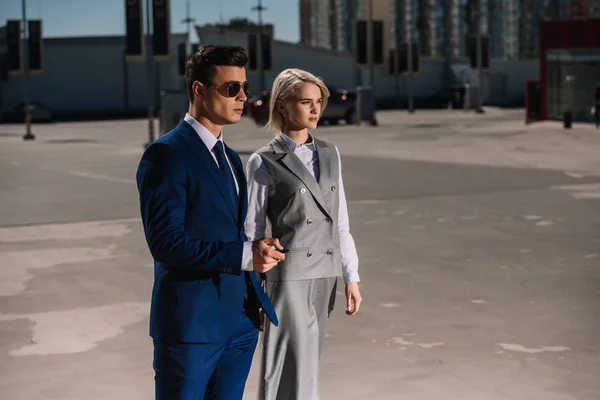 Young stylish business people walking on parking — Stock Photo