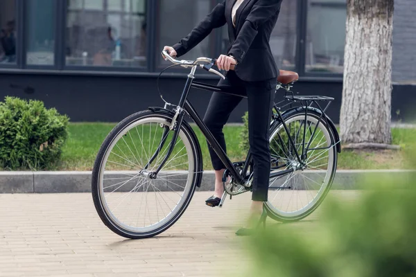Plan recadré de femme d'affaires en costume avec vélo rétro dans la rue — Photo de stock