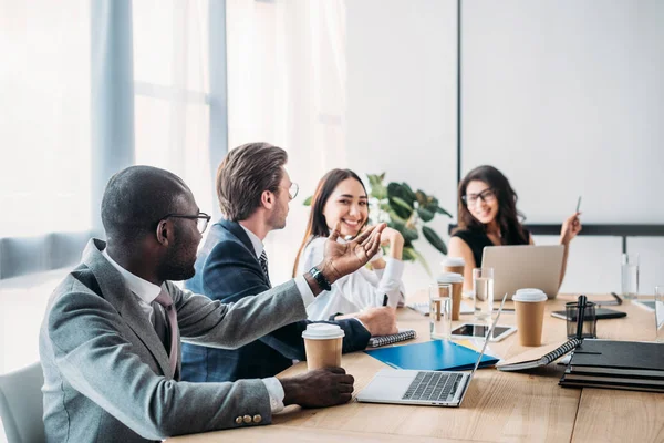 Selective focus of multicultural business people having business meeting in office — Stock Photo