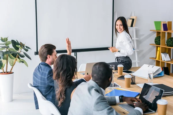 Visión parcial del equipo empresarial multiétnico que tiene una reunión de negocios en el cargo - foto de stock