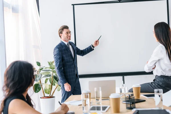 Vue partielle de l'homme d'affaires multiracial et des femmes d'affaires travaillant ensemble sur le projet d'entreprise dans le bureau — Photo de stock