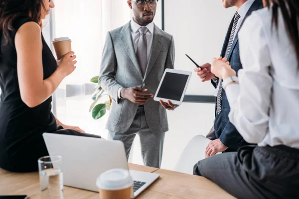 Partial view of group of multiracial business coworkers in formal wear discussing new business plan in office — Stock Photo