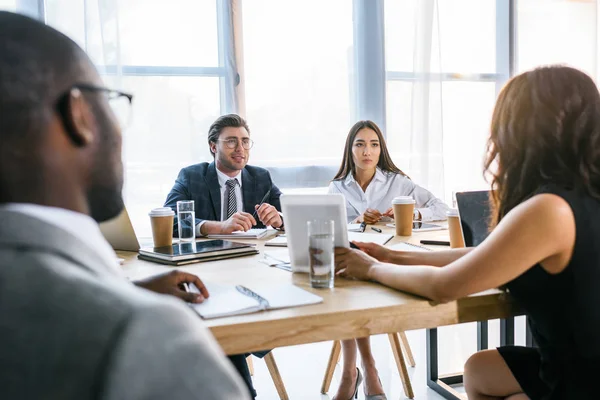 Selektiver Fokus einer Gruppe multiethnischer Geschäftskollegen, die während eines Geschäftstreffens im Büro über die Strategie diskutieren — Stockfoto