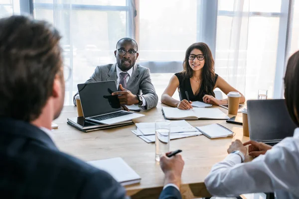 Selective focus of group of multiethnic business colleagues discussing strategy during business meeting in office — Stock Photo