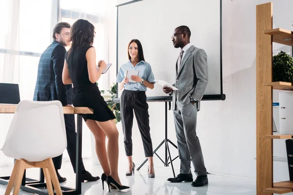 Grupo multiétnico de empresarios en ropa formal discutiendo proyecto juntos en el cargo - foto de stock