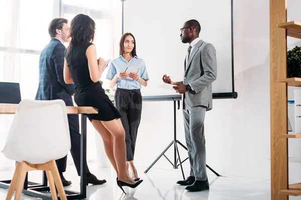 Grupo multiétnico de empresários em vestuário formal discutindo projeto em conjunto no escritório — Fotografia de Stock