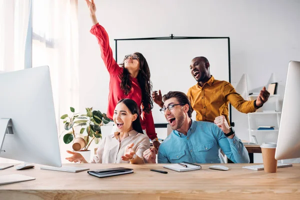 Glückliches multiethnisches Business-Team, das gemeinsam im Büro an einem Projekt arbeitet — Stockfoto