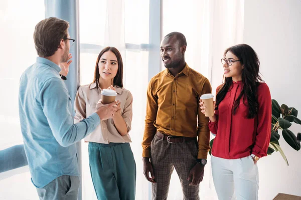 Group of multicultural business people having conversation during coffee break in office — Stock Photo